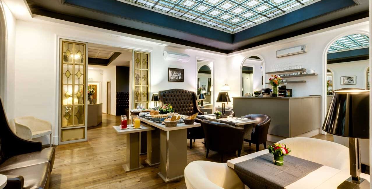 Area colazione e lounge di Piazza Farnese Luxury Suites con soffitto a vetrate decorative.