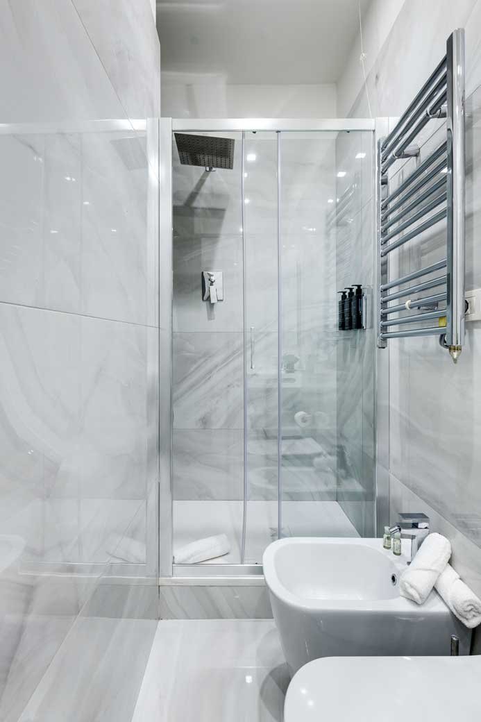 Bagno della Suite con vista e balcone di Piazza Farnese Luxury Suites con doccia in vetro e finiture in marmo