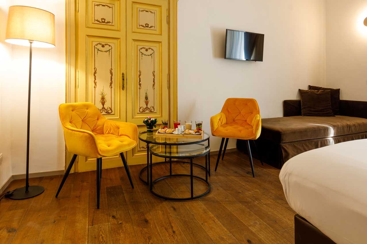 Zona relax della Suite con vista di Piazza Farnese Luxury Suites con poltrone e area soggiorno elegante