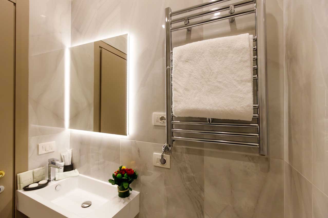 Bagno della suite con vista di Piazza Farnese Luxury Suites con lavabo e scaldasalviette