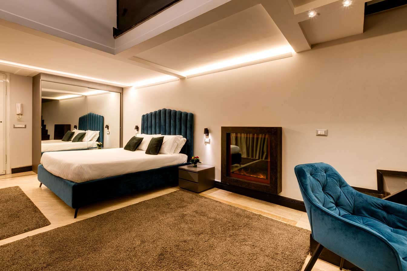 Camera della suite duplex loft di Piazza Farnese Luxury Suites con camino